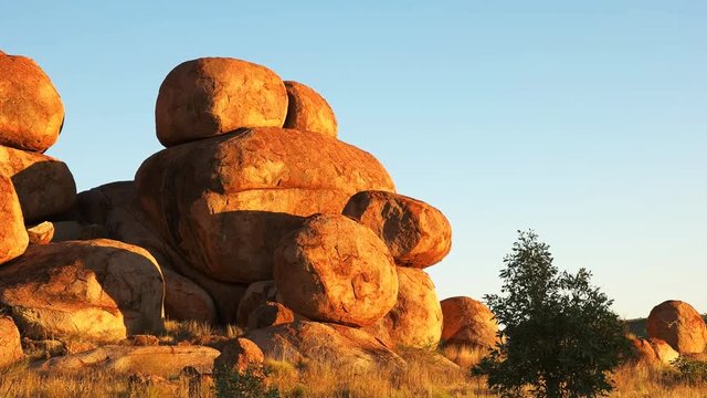 a close up zoom out shot of the devil's marbles in australia's northern territory at sunrise