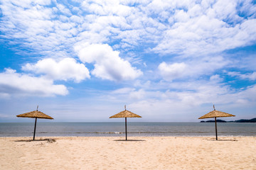Obraz na płótnie Canvas Good day in the cloudy secluded beach parasol