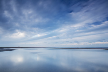 Blue Clouds at Dutch beach with reflections