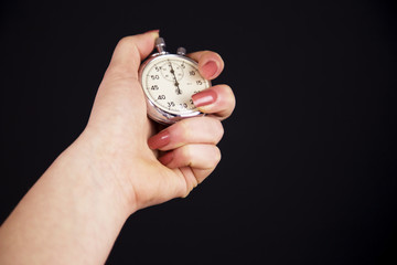 woman holding Vintage stopwatch on black background