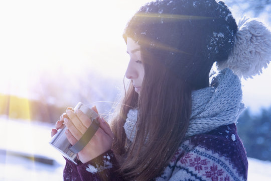 Close up of young beautiful woman drinking hot beverage. (Christmas, new year, celebration concept)