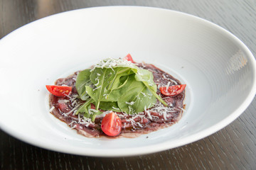  beef carpaccio with sliced on white plate