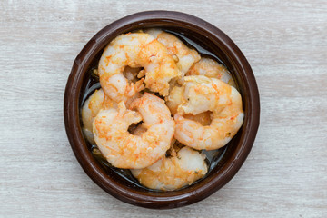 Prawns with garlic. Popular dish of Spanish cuisine. The ingredients are peeled prawns, garlic and olive oil. Served in clay pot They must be eaten quickly, without getting them to cool down.
