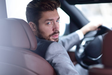 Close-up of a businessman sitting at the wheel of a car