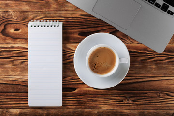 Top view of studying process with copybook, book and laptop. Cups of coffee on the table