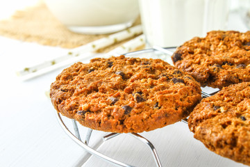 Homemade oatmeal cookies. Cookies on an iron grate on a wooden white table.