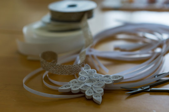 Beautiful Christmas tree decoration, white snowflake, quilling, made of thin white strips. Concept hobby, homemade decoration.