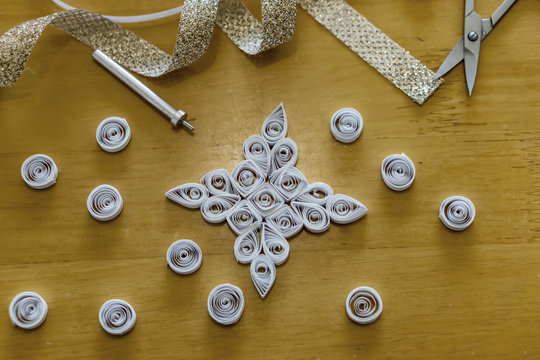Beautiful Christmas tree decoration, white snowflake, quilling, made of thin white strips. Concept hobby, homemade decoration.
