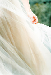bride's hand holding soft tulle wedding dress