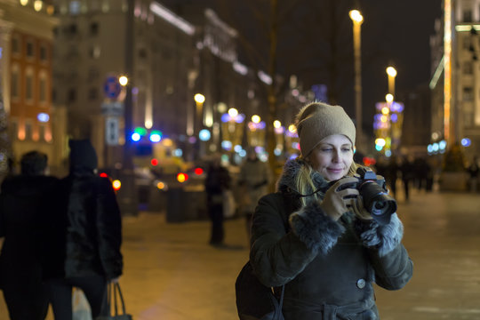 Woman photographer makes photos in the night city