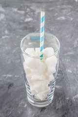 Glass with sugar cubes is an unhealthy diet. The contents of sugar in sweet soda.