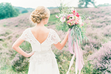 bride holding pink coloured bouquet