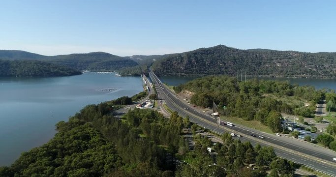 Sydney &ndash; Newcastle motorway M1 at Hawkesbury river crossing water via new and old bridges in aerial panning
