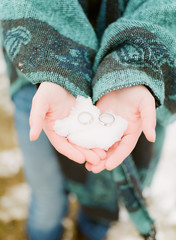 wedding rings on snow in hands
