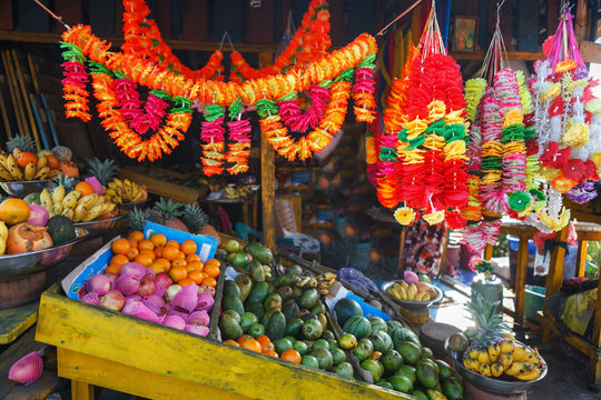 Sellers in street shop sell fresh fruits, flowers, bananas, papaya and vegetables for praying and donation. Traditional Asian local market near Buddhist temple