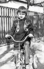 Vintage photo of little girl on old bicycle © darkbird