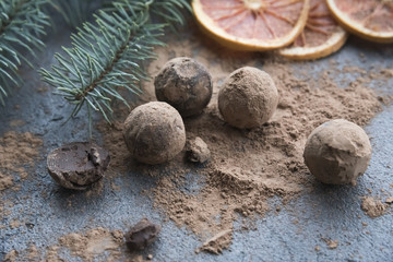 chocolate truffles with cocoa powder on the  dark background  and christmas decoration 