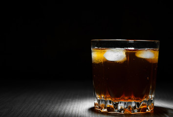 glass of iced tea on dark wooden background with copy space