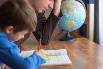 Sad father tired about helping son in mathematics homework
