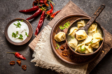 Russian dumplings with meat and broth and herbs in a rustic style