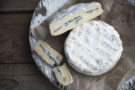 camembert cheese with blue mold on the wooden background 