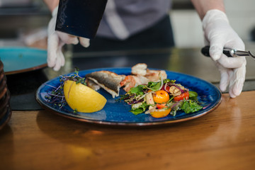 the chef gives a plate of seafood and salad
