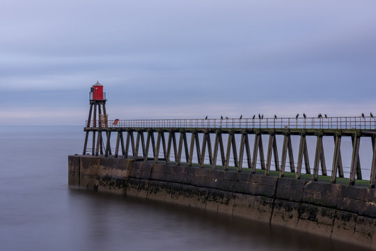 Whitby harbour entrance, east pier and beacon, Yorkshire, UK.