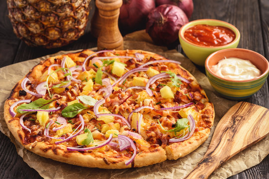 Fototapeta Homemade hawaiian pizza on black wooden background.