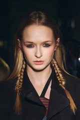 Close up portrait of hippie girl with pigtails in hair looking stern and wearing shabby coat