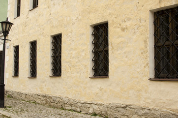 Windows with bars on the wall of the old building