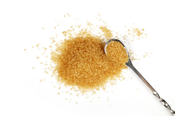 Full spoon and pinch of brown cane sugar on white