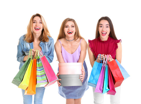 Happy young women with shopping bags and boxes on white background