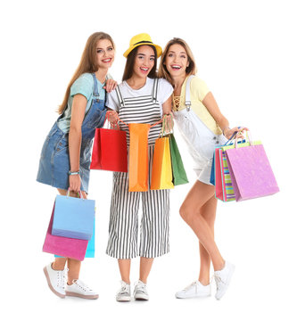 Happy young women with shopping bags on white background
