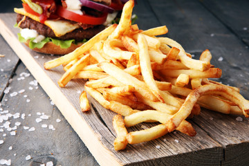 fresh tasty burger and french fries on wooden table