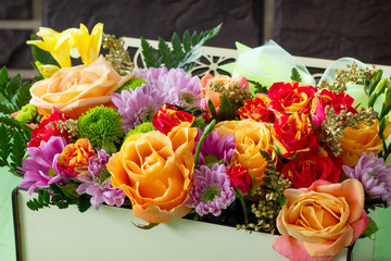 Background wedding or Valentine's Day. Basket bouquet of roses and chrysanthemums on a vintage wooden background.