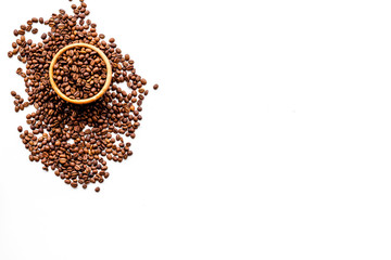 Fresh roasted coffee beans in bowl on white table top view copyspace. Coffee background.