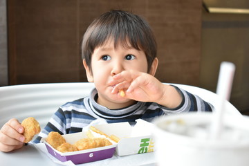 Little boy dreams over the fries and nuggets