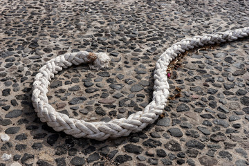 Strong bright rope on the dark stone floor © kelifamily
