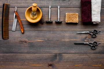 Vintage barbershop tools. Razor, comb, sciccors, brush on dark wooden background top view copyspace