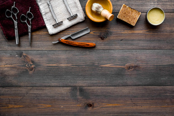 Vintage barbershop tools. Razor, sciccors, brush on dark wooden background top view copyspace