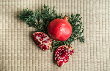 Ripe pomegranate fruit isolated on tatami background, top angle