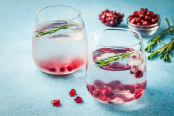 Alcohol free pomegranate rosemary drink on light blue background. Selective focus, copy space. 