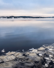 Ice shapes with melted lake at winter landscape in Finland