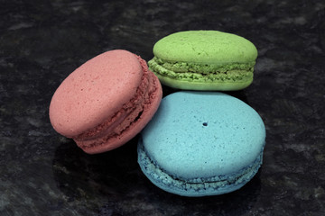 Colorful macarons on black granite table