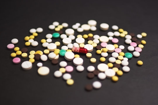 tablets and pills on dark background