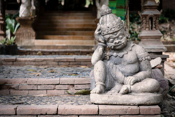 Fototapeta na wymiar Statue of little, thinking demon in front of temple in Chiang Mai, Thailand