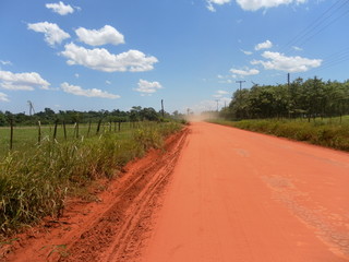 Fototapeta na wymiar road made of red earth in a village in Paraguay