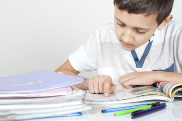 Naklejka premium boy is sitting at desk doing his homework
