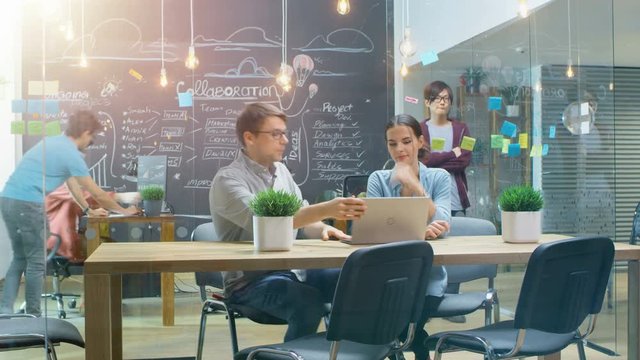 Time-Lapse of the Busy Creative Office Where Stylish Young People Work on Personal Computers, Have Meeting and Discussions. Shot on RED EPIC-W 8K Helium Cinema Camera.