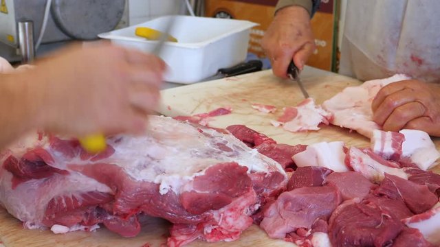 Butcher cutting fresh pork becon in Slaughterhouse. 